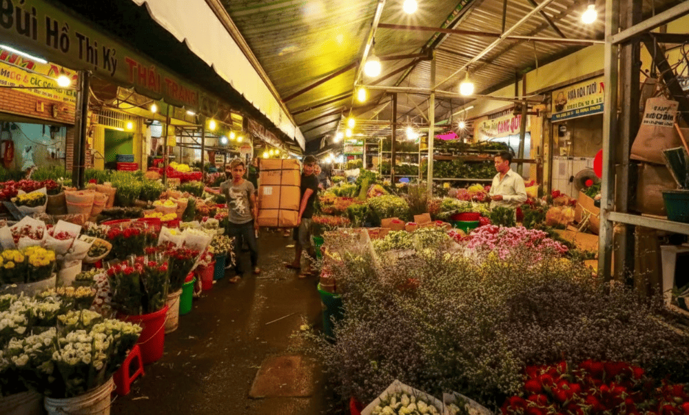 Vendors setting up flower stalls at dawn, preparing for the vibrant rush of the day